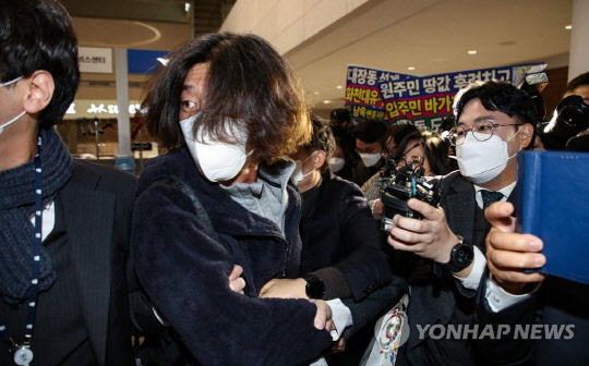 미국에 체류 중이던 대장동 개발 로비·특혜 의혹의 핵심 인물 남욱 변호사가 18일 오전 인천국제공항 제2여객터미널로 귀국해 검찰에 체포된 뒤 서울중앙지검으로 압송되고 있다. [영종도=연합뉴스]